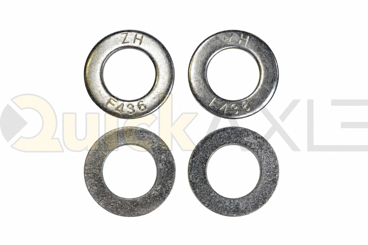 Flat washers arranged to show their central openings and stamped markings.