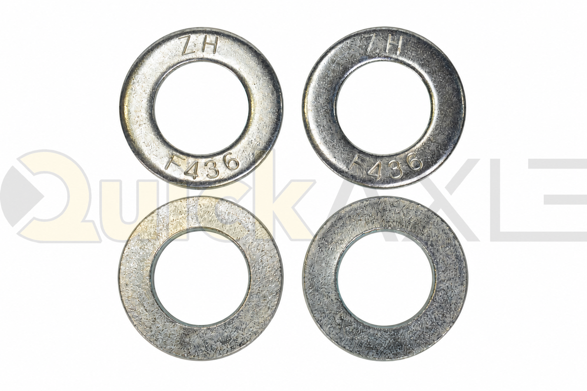 Flat washers arranged to show their central openings and stamped markings.